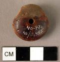 Disk-shaped amber pendant with pronounced tab for cross-drilled hole