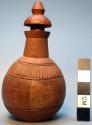 Carved wooden jar w/ stopper, small, round body, flat base, incised design.