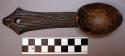Spoon of dark wood with incised lines on handle and hole on tip of handle
