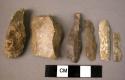 10 small flint blades; 2 crude flint flakes