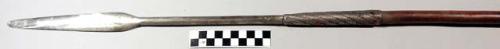 Spear, ovate blade, long stem, braided metal wrap at base of stem, wood shaft