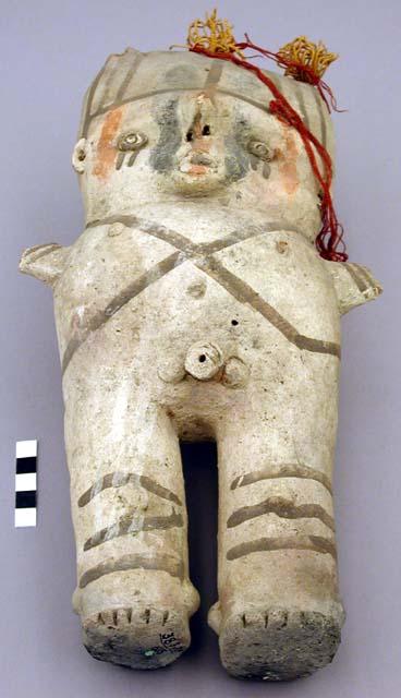 Ceramic, male figurine with colored wool tufts attached to top of head