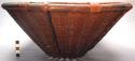 Basket, woven fiber, reed rim, dark brown, braided vertical strips on exterior.