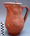 Lidded molded pottery pitcher.