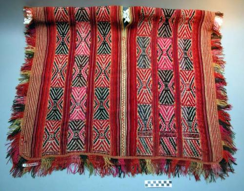 Handwoven wool poncho, weft faded, geometric pattern of red, white, blue, green,