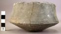 Ceramic bowl, brown, incised linear design, tapering base and sides,mended