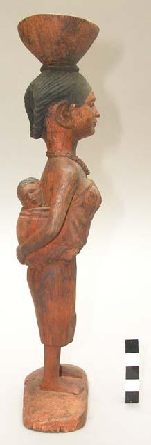 Wood carving of woman dressed for visiting