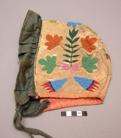 Child's bonnet of beaded leather lined with pink cotton cloth.