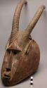 Wooden helmet mask, human face with large antelope horns (42" high)