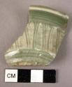 Ceramic bowl rim sherd, green w. white vegetal design, glazed, flared rim