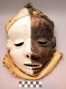 Carved wood mask with black and white zonally painted anthropomorphic face and g
