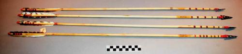 Obsidian pointed arrows; the shafts of each set of arrows have like decorations;