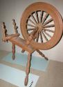 Wooden spinning wheel, turned legs, nailed together, metal hardware.