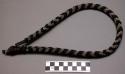 Woman's necklace of bent stick covered with black, white, and red beadwork, join