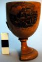 Cup, goblet shaped, wood, printed scene of buildings 1 side, pedestal base brkn