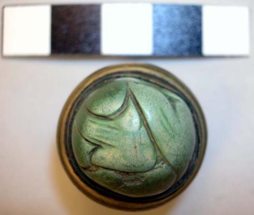 Metal button, carved greenstone inset