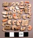 Organic shell bead fragments, mostly discoidal, one with 2 perforations