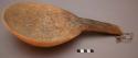 Wood ladle with wide thick handle. Use-marks inside. Piece of cloth tied through