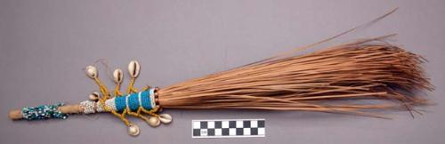 Straw whisk broom. Handle is decorated with beads and shells.