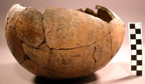 Ceramic partial vessel, remnants of red slip, very faded, rounded base