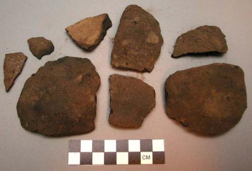 Bowl - body & rim sherds; dark brown; crumbling