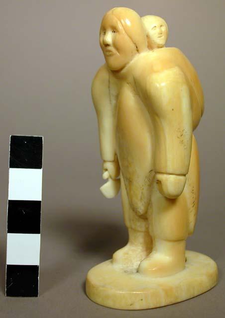 Ivory carving - mother with baby on her back, holding a knife