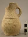 Small almost complete vessel of whitish clay and incised decoration