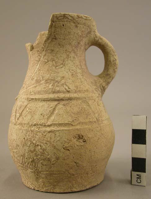 Small almost complete vessel of whitish clay and incised decoration