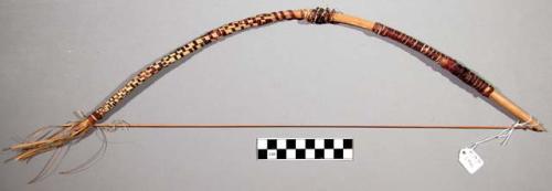 Bow used for ceremonial purposes in a dance, strips of grass held in place by sm