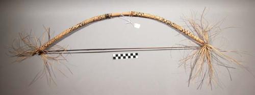 Bow used for ceremonial purposes in a dance, wound with checkered pattern straw