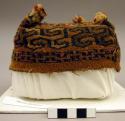 Hat of woven tapestry, 4 cornered, tassels on each corner