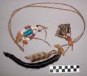 Shoshone medicine necklace. Many objects hang off twisted piece of leather.