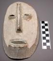 Mask, wooden. Covered with kaolin, 9.5 in.  Used for Yananio grade of Bwami soci