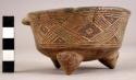 Maroon incised ware tripod bowl with open mouth and designs all around