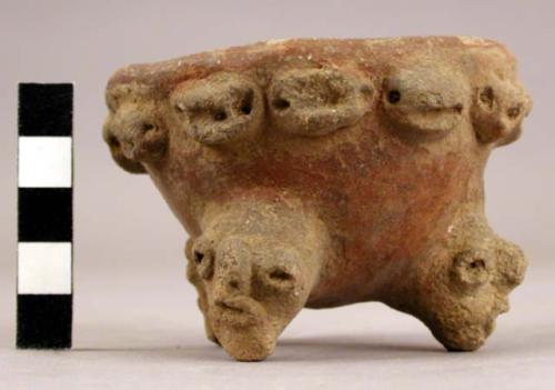 Small red on white tripod adorno decorated pottery vessel (one leg missing)