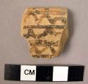 Ceramic rim sherd, buff ware with black painted linear design
