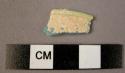 Glass fragment, opaque blue, covered w. white material, rim fragment