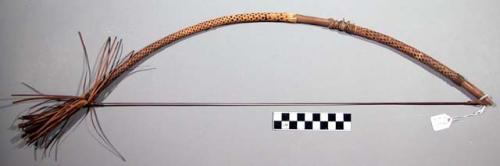 Bow used for ceremonial purposes in a dance, wound with checkered pattern straw