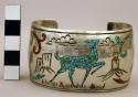 Wide silver cuff bracelet inlaid with chipped stone forming deer motif