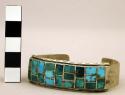 Cuff bracelet inlaid w/turquoise squares, stamped design along borders