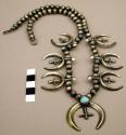 Silver necklace with najas with crosses in centers, single turquoise stone