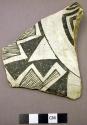 Ceramic; sherd - body; black on white geom. design; portion curved (neck)