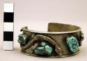Cuff bracelet, flat silver band adorned w/ 2 rattlesnakes and turquoise nuggets