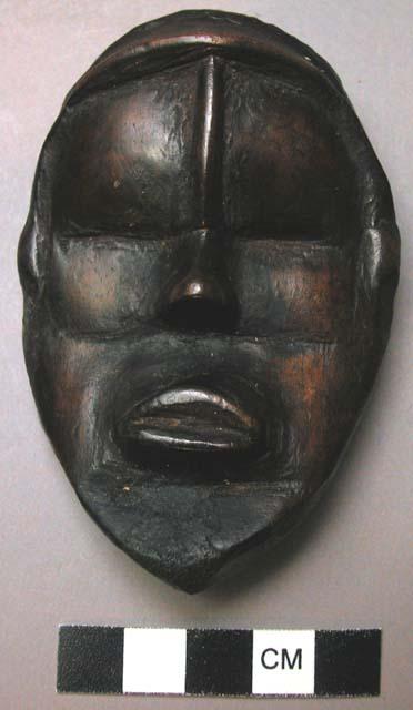 Small wooden mask - property of a man who prays to it for good luck and also sac