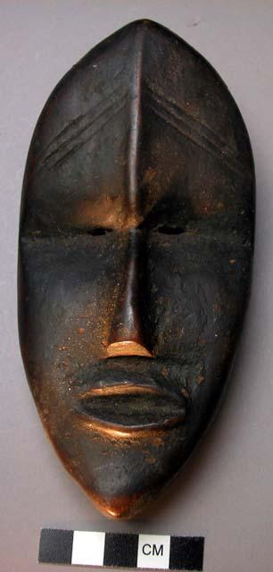 Miniature wooden face mask.