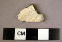 Small unpatinated triangular flint point with cortex on upper surface