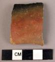 Potsherd - shiny red and black outside, dull striated grey inside; fragment of s