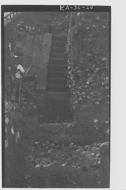 Man standing next to south half of Structure 6 stairway