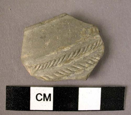 Ceramic rim sherd, thin fine grey ware, wheel made, white filled incised design