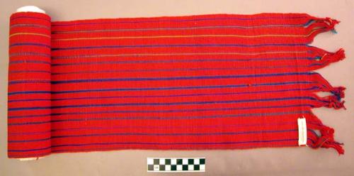 Man's sash to hold pants in place.  Primarily red, with thin multicolored stripe